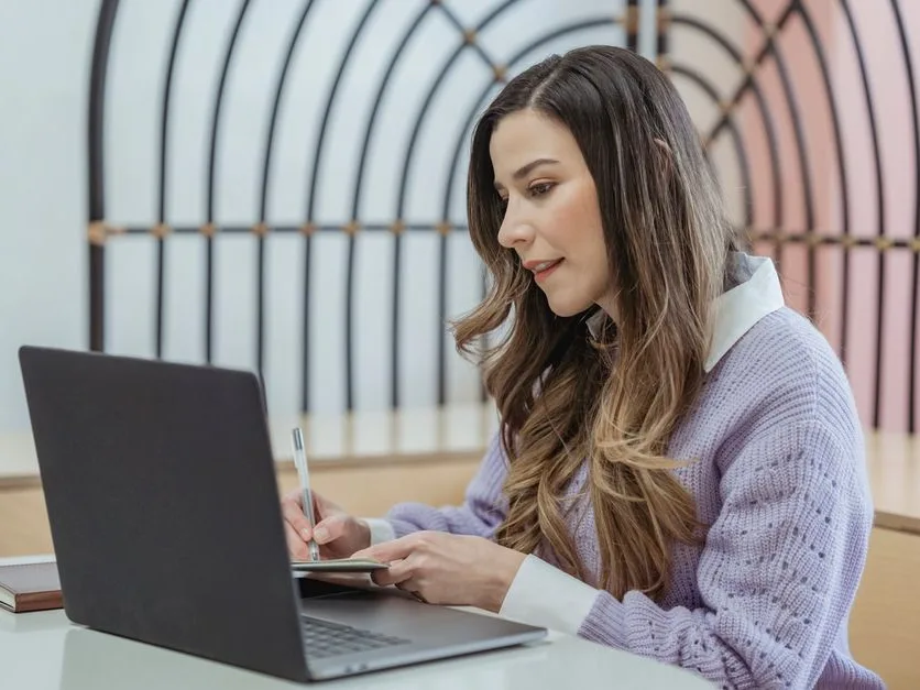 Une dirigeante rédige la fiche de poste à sa table de travail